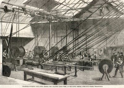 Benches and drums of cable in a factory, wires strung across the room