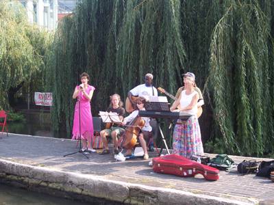 Musicians stand close to the edge on the lock side in colourful costumes.