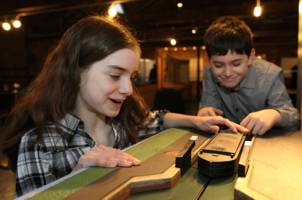 A girl and a boy work a boat through our model lock