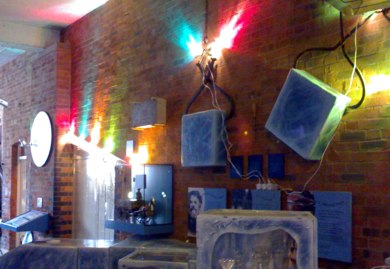 Brick wall fitted with displays and lit with coloured lamps