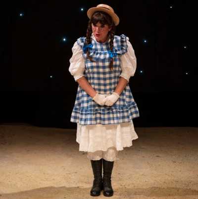 Female artist dressed as Victorian girl on stage