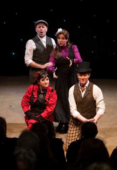 Performers pose in a group against a dark background